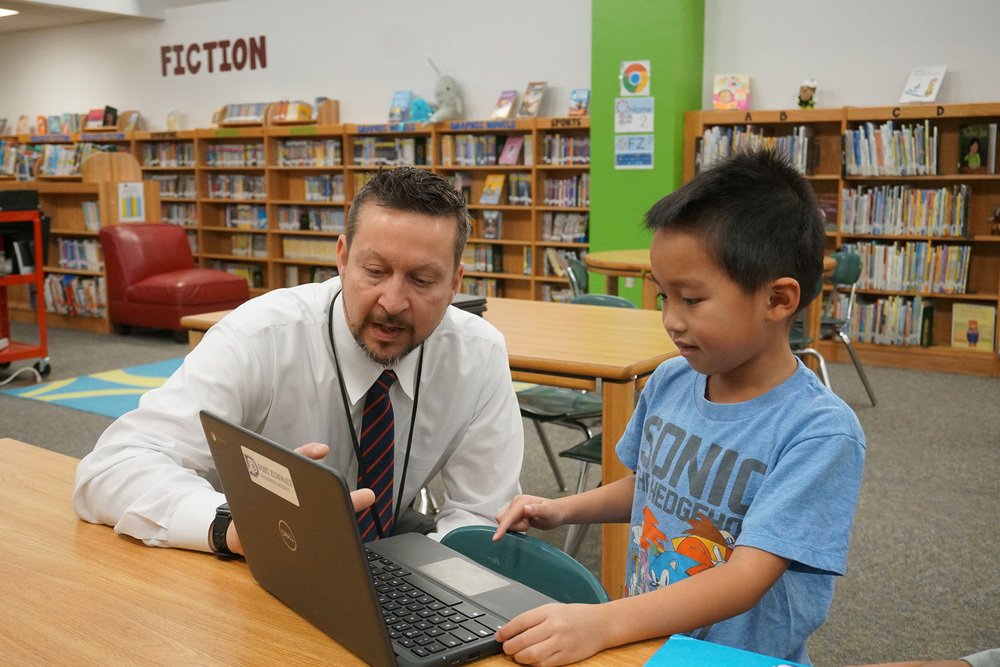 First-grader explains a lesson on laptop to the principal
