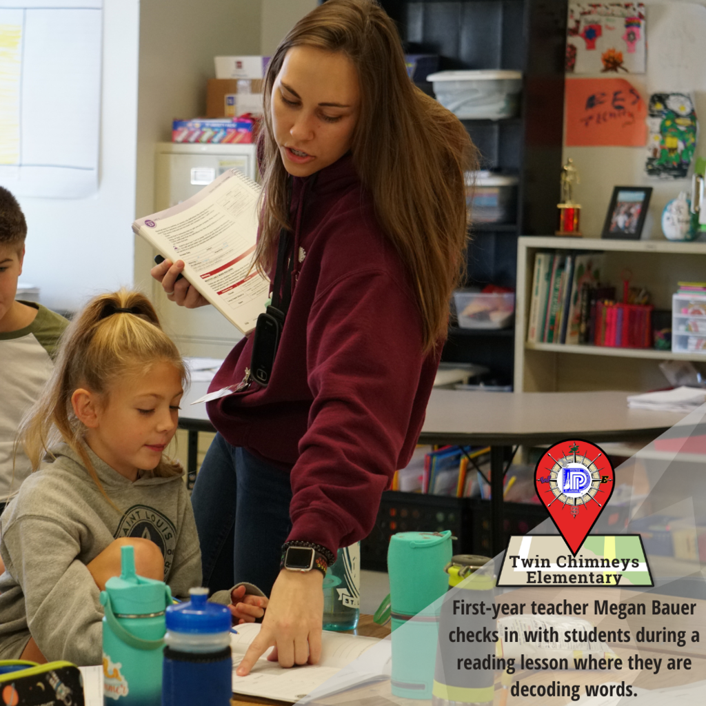 First-year teacher Megan Bauer checks in with students during a reading lesson where they are decoding words.