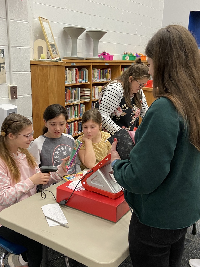 Students ring up a teacher's purchase at the book fair.
